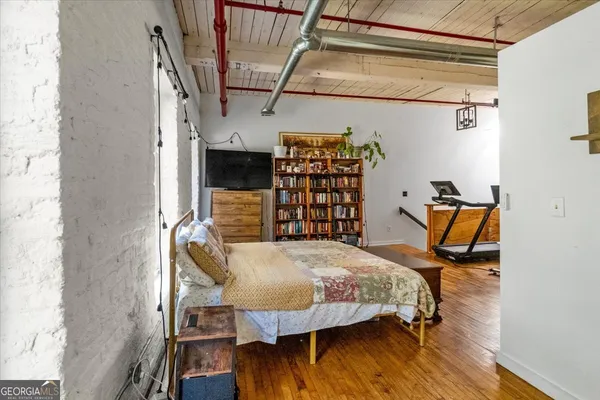 a bedroom with a bed and wooden floor