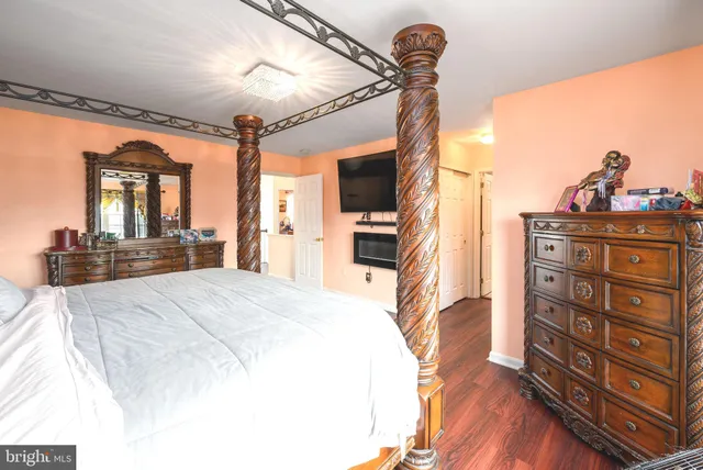 a spacious bedroom with a bed and wooden floor