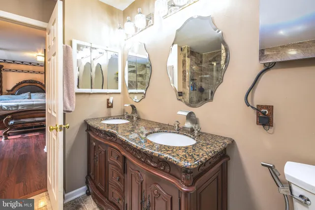 a bathroom with a granite countertop sink a toilet and a mirror