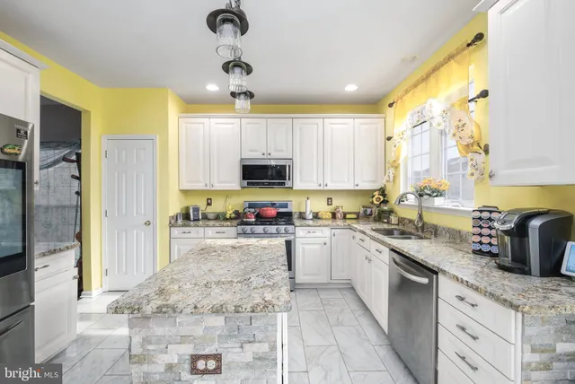 a kitchen with a sink a counter top space cabinets and stainless steel appliances