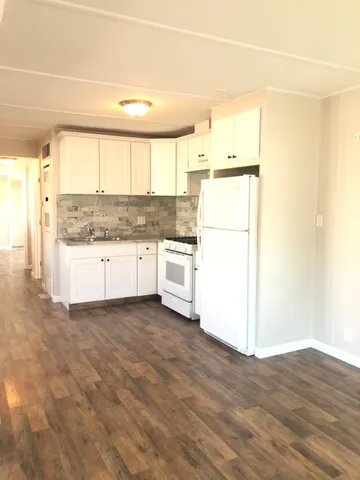 a kitchen with a refrigerator a stove top oven and a large window
