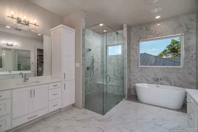 a bathroom with a double vanity sink mirror and bathtub