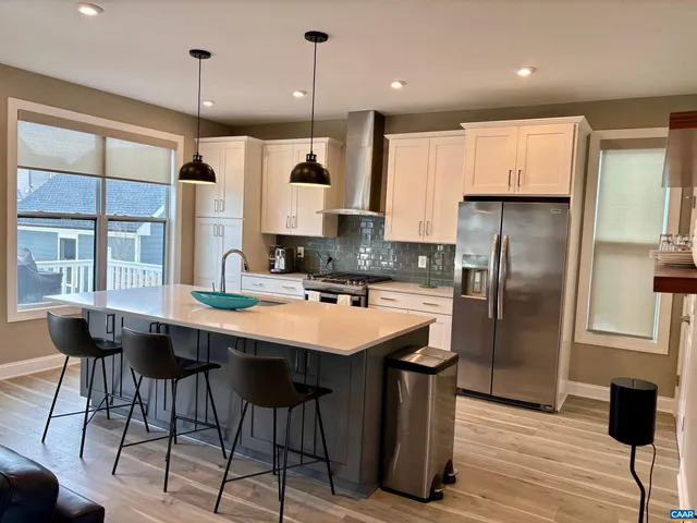 a kitchen with stainless steel appliances granite countertop a sink a stove and a refrigerator