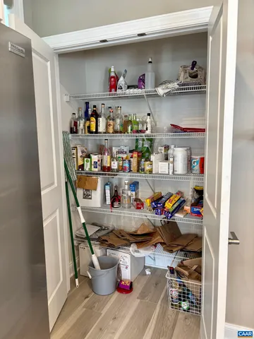 a room with stainless steel appliances a shelf and a book shelf