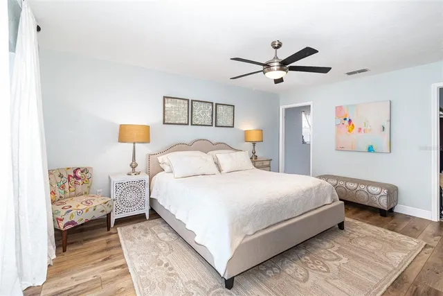 a bedroom with a bed and wooden floor
