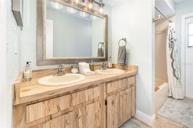 a bathroom with a double vanity sink and a mirror