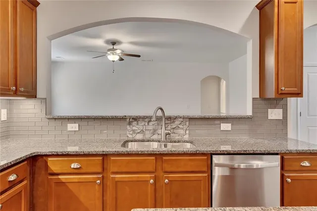 an empty room with ceiling fan and window
