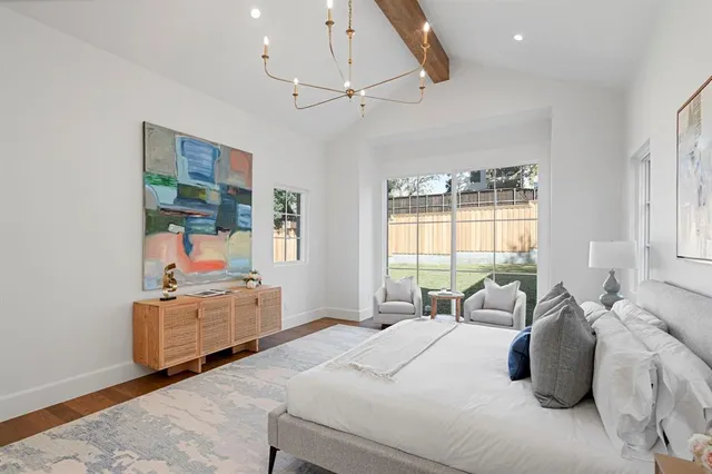 a bedroom with a bed wooden floor and window