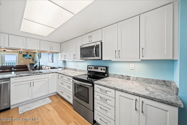 a kitchen with stainless steel appliances granite countertop a refrigerator and a sink