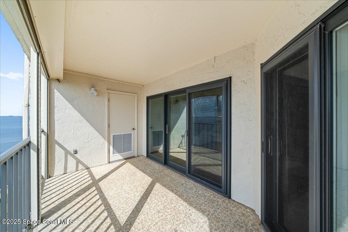 3220 River Villa Way, Unit 151 Melbourne Beach, FL 32951 - Photo 10 of 51 a view of a hallway with wooden floor and staircase
