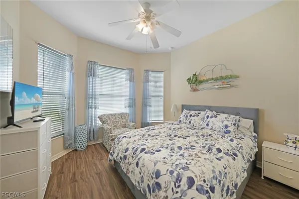a bedroom with a bed and a flat tv screen on the dresser