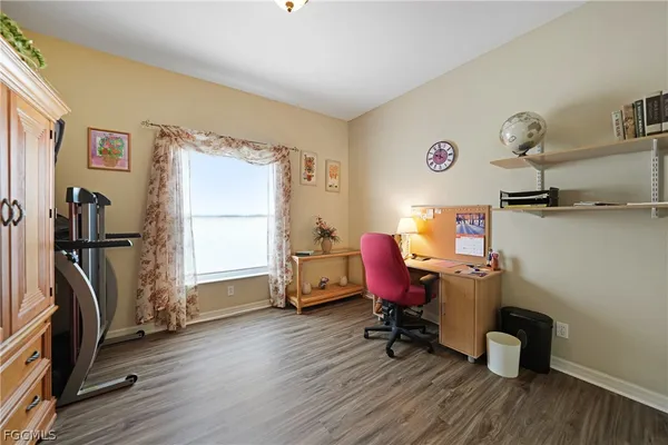 a view of a workspace with furniture and a window