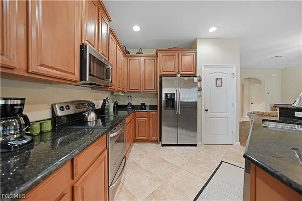 a kitchen with stainless steel appliances granite countertop a refrigerator stove and sink
