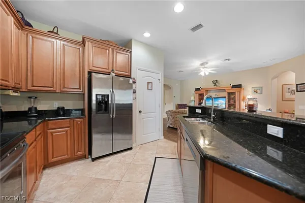 a kitchen with stainless steel appliances granite countertop a refrigerator a sink and a stove