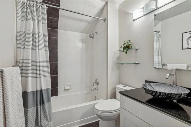 a bathroom with a granite countertop sink toilet a mirror and shower
