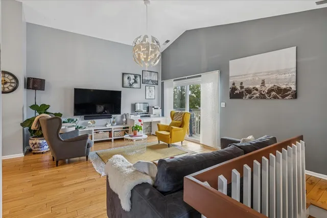 a living room with furniture kitchen view and a flat screen tv