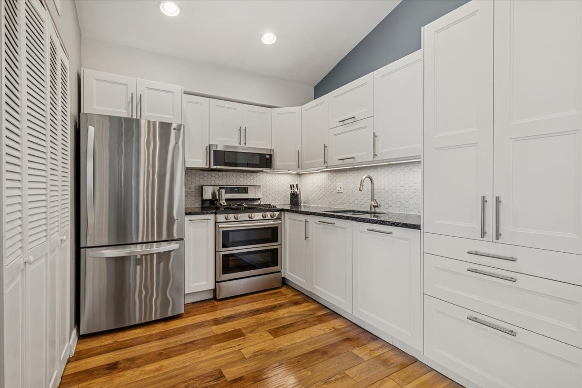 1321 Longacre Lane Wheeling, IL 60090 - Photo 7 of 23 a kitchen with granite countertop a refrigerator stove and wooden cabinets