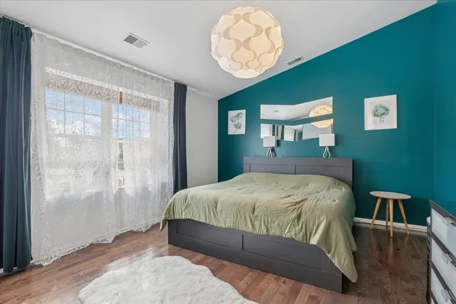 a bedroom with a bed mirror and a window