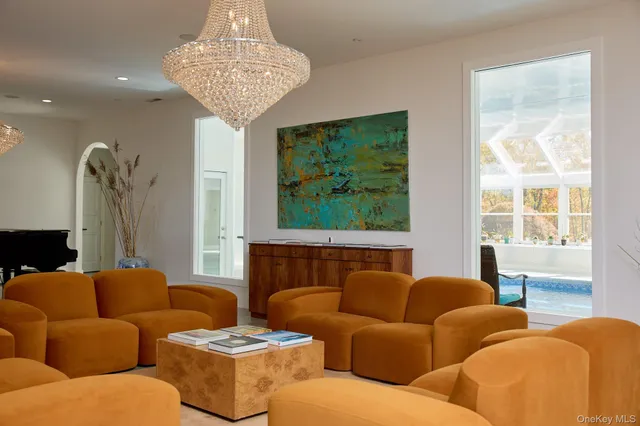 a living room with furniture a large window and a chandelier