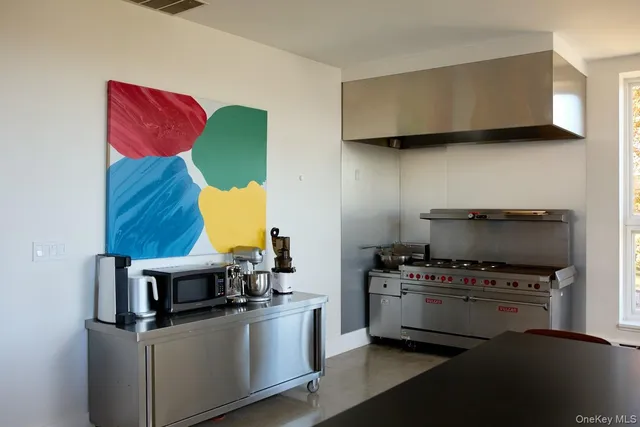 a kitchen with stainless steel appliances a stove a microwave and a cabinets