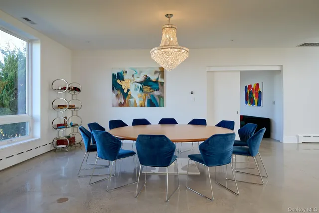 a view of a dining room with furniture a chandelier and wooden floor