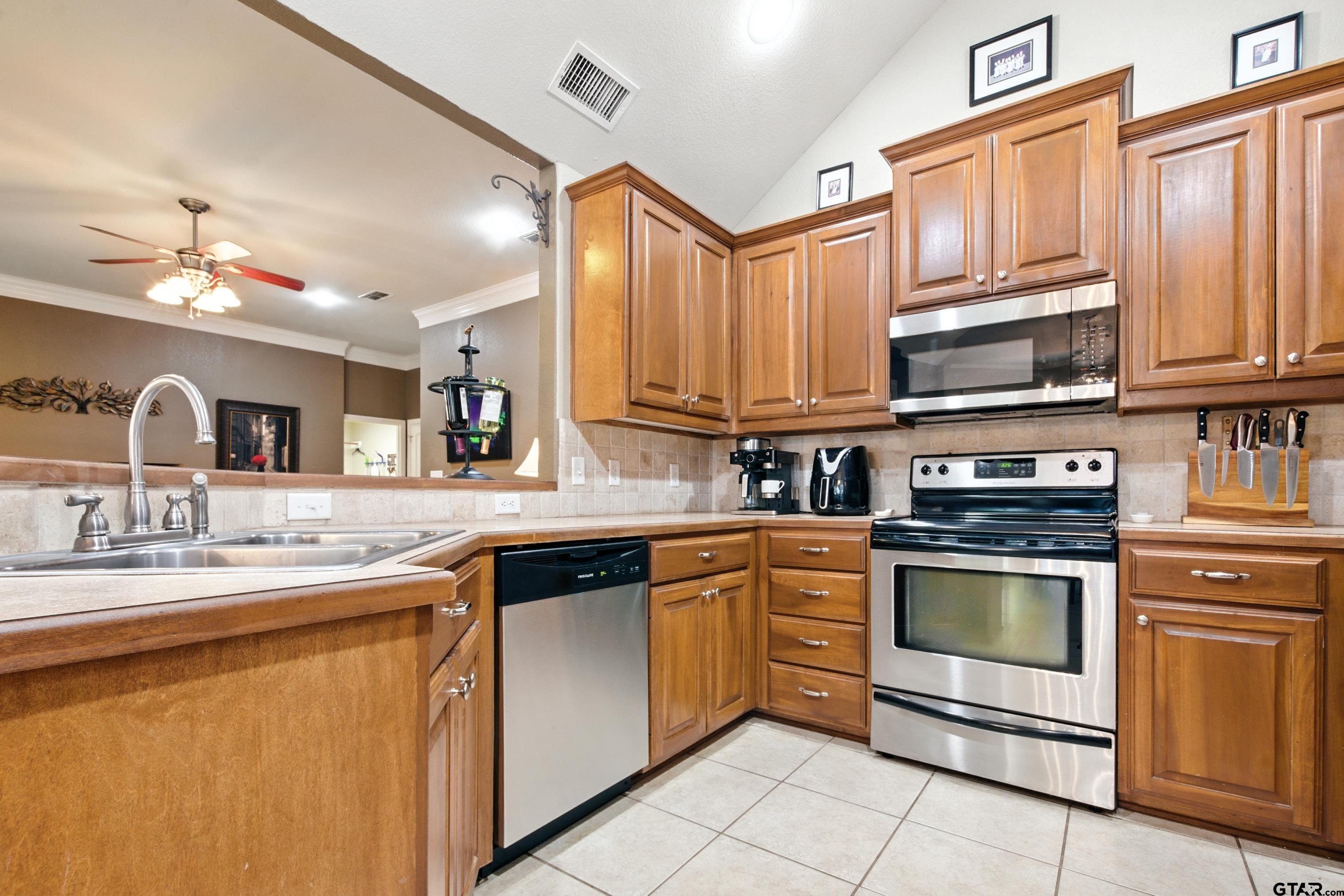 704 Windover Lane Bullard, TX 75757 - Photo 9 of 23 a kitchen with stainless steel appliances granite countertop a sink stove and cabinets