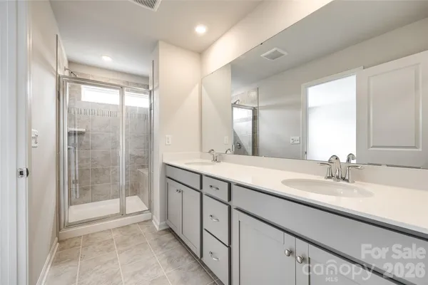a spacious bathroom with a double vanity sink mirror and shower