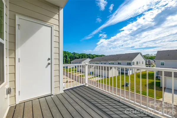 a view of a balcony with wooden floor and fence