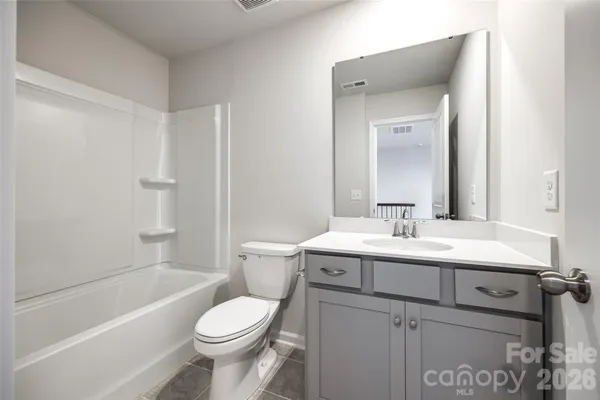 a bathroom with a toilet sink vanity tub and shower