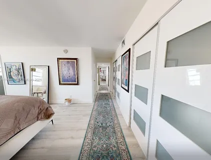 a bedroom with a bed and a painting on the wall