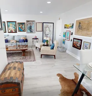 a living room with furniture and painting on the wall