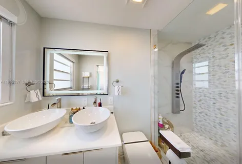 a bathroom with a sink and mirror with toilet