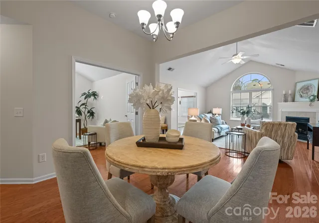 a dining room with furniture a large window and wooden floor