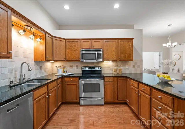 a kitchen with stainless steel appliances granite countertop a sink and a stove