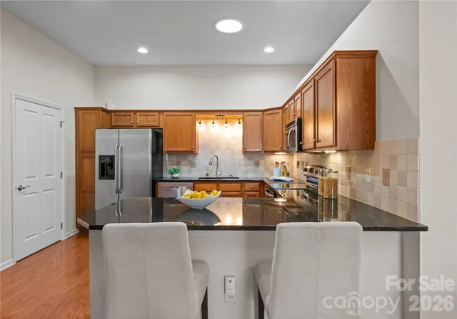 a kitchen with stainless steel appliances granite countertop a sink refrigerator and microwave