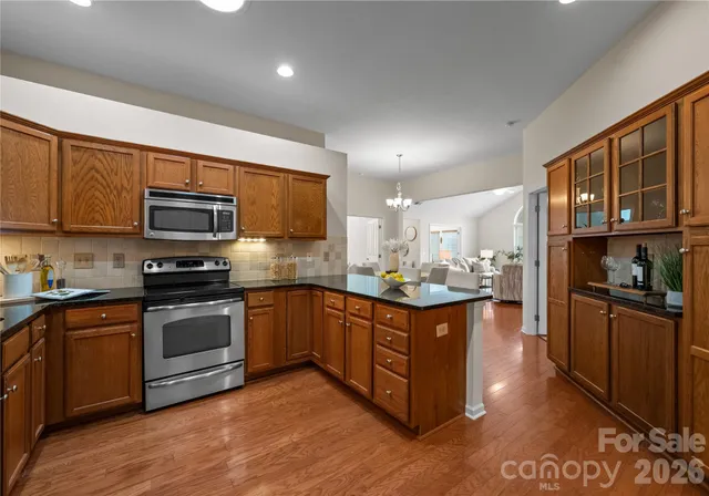 a kitchen with stainless steel appliances granite countertop a stove a sink and a microwave
