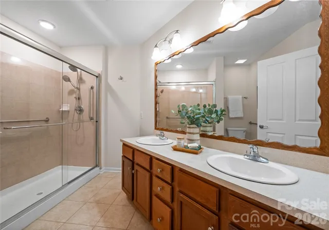 a bathroom with a granite countertop sink mirror and shower