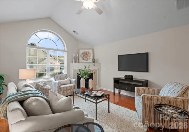 a living room with furniture a flat screen tv and a window