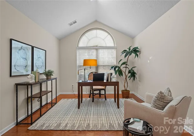 a living room with furniture a wooden floor and a potted plant