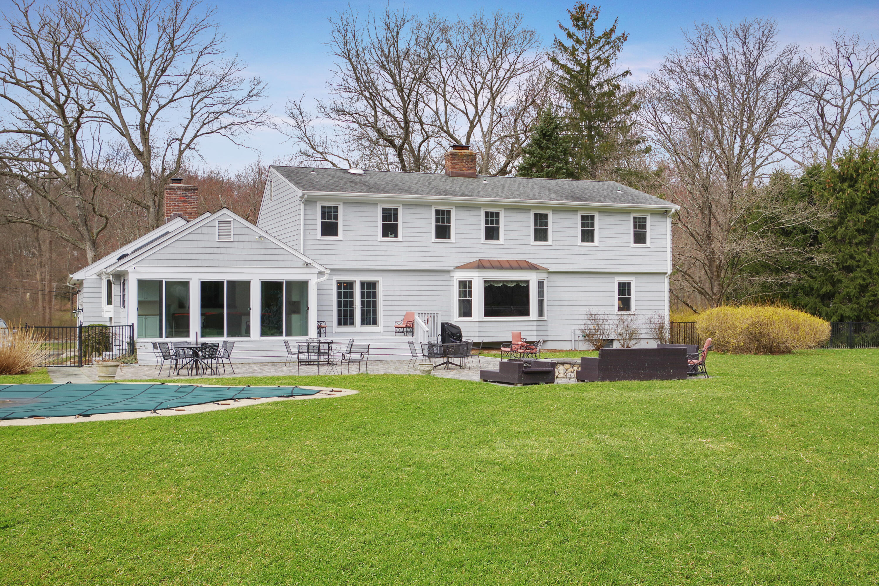 62 Beech Road New Canaan, CT 06840 - Photo 3 of 40 a front view of a house with a yard patio and swimming pool