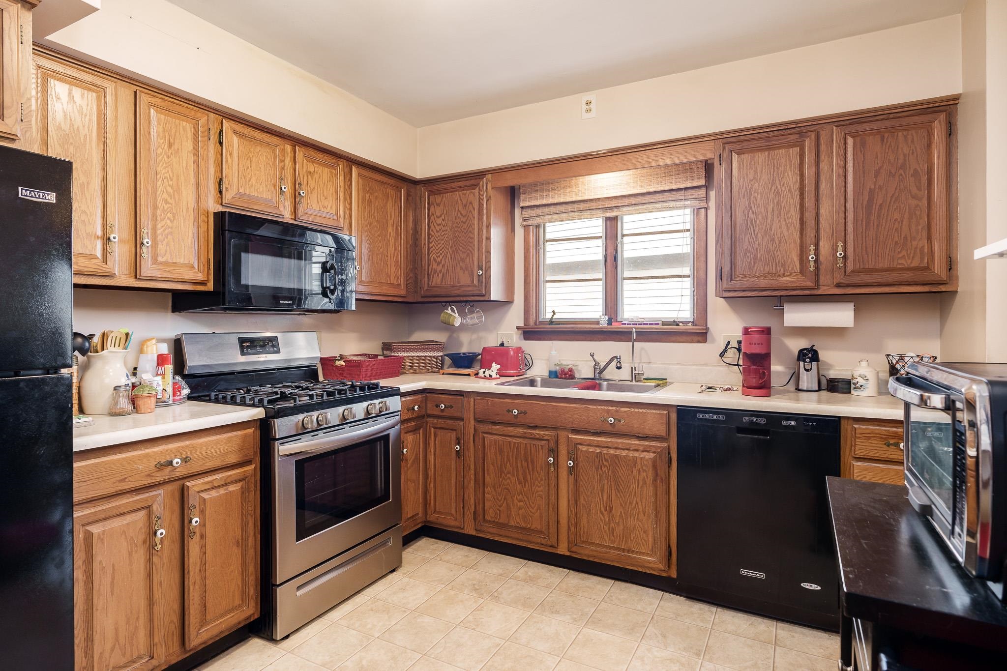 3704 Highcrest Road Rockford, IL 61107 - Photo 16 of 33 a kitchen with stainless steel appliances granite countertop wooden cabinets a sink a stove a window and cabinetry