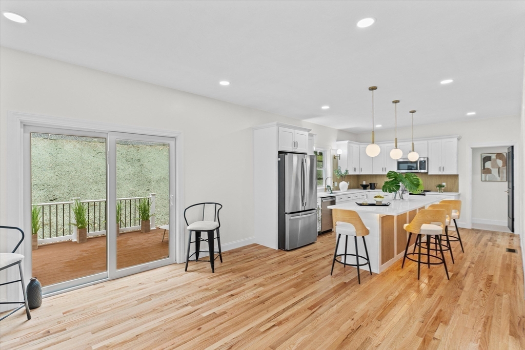 508 Pine Street Leicester, MA 01524 - Photo 8 of 34 a kitchen with stainless steel appliances granite countertop a refrigerator a microwave a stove and a dining table with wooden floor