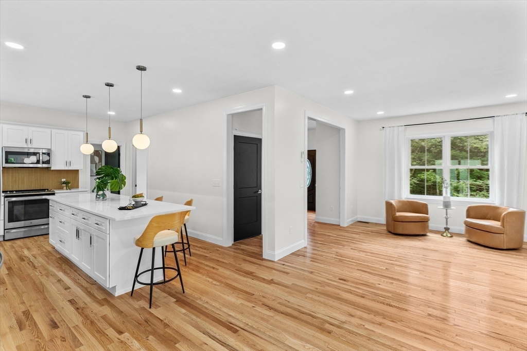 508 Pine Street Leicester, MA 01524 - Photo 9 of 34 a kitchen with stainless steel appliances kitchen island granite countertop a refrigerator a stove a microwave oven with a dining table and chairs with wooden floor