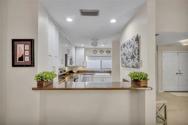 a kitchen with granite countertop white cabinets stainless steel appliances and a sink