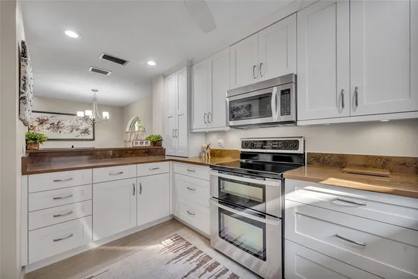 a kitchen with granite countertop a sink cabinets and stainless steel appliances