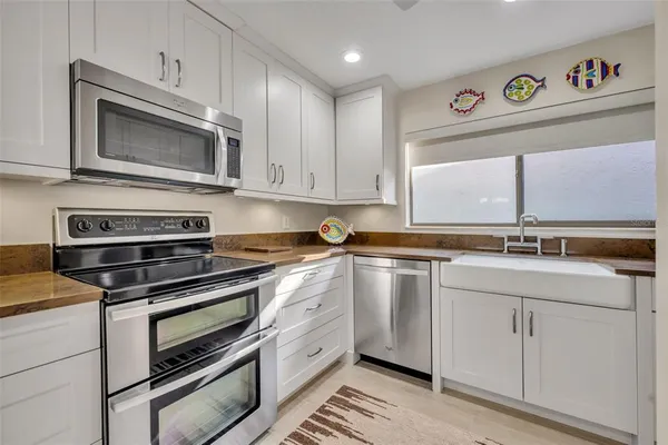 a white kitchen with a sink and a refrigerator