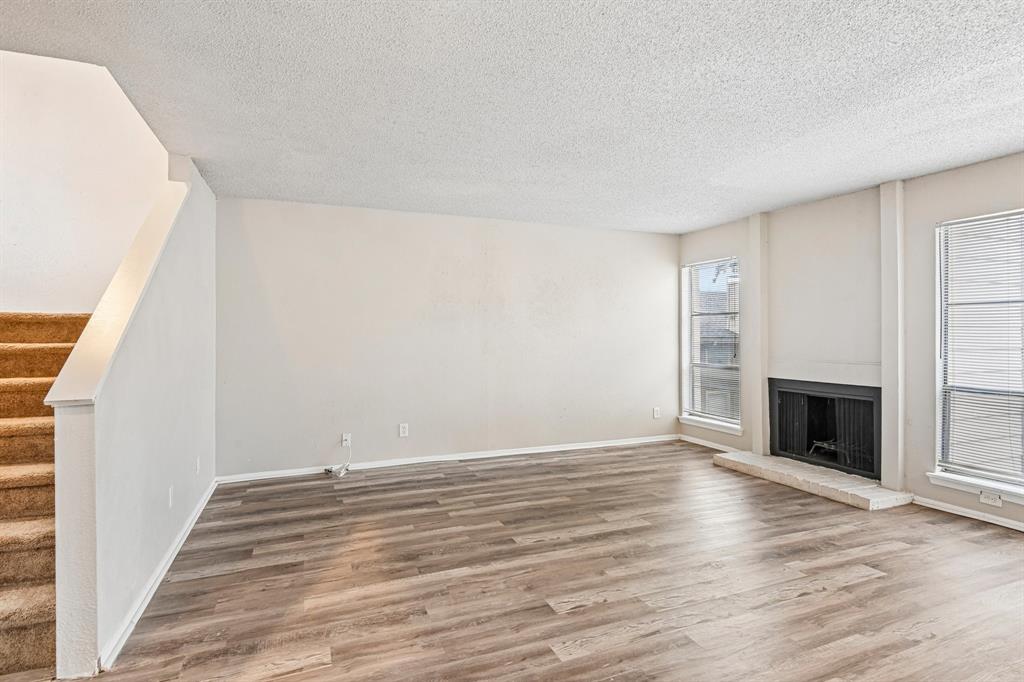 5534 Boca Raton Boulevard, Unit 292 Fort Worth, TX 76112 - Photo 7 of 31 a view of empty room with wooden floor and fireplace