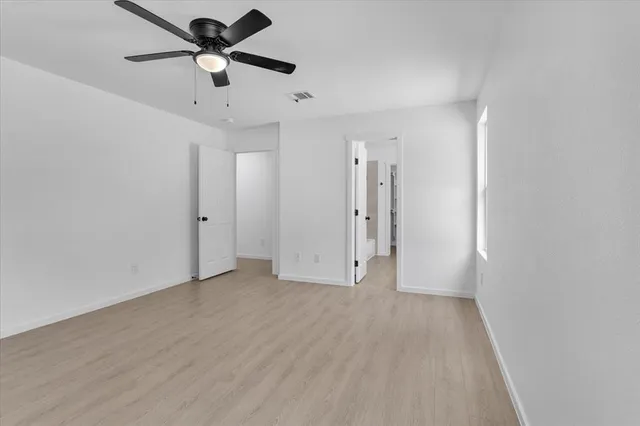 an empty room with a empty space and a ceiling fan