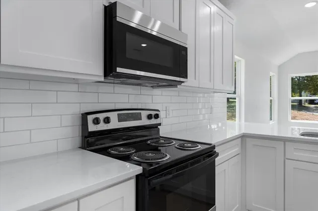 a kitchen with white cabinets and stainless steel appliances
