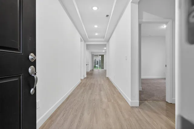 a view of a hallway with wooden floor